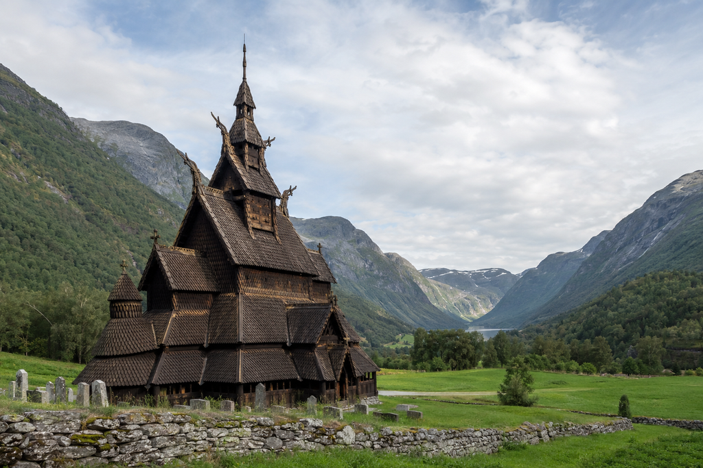 Historische norwegische Stabkirche in einem grünen Bergtal